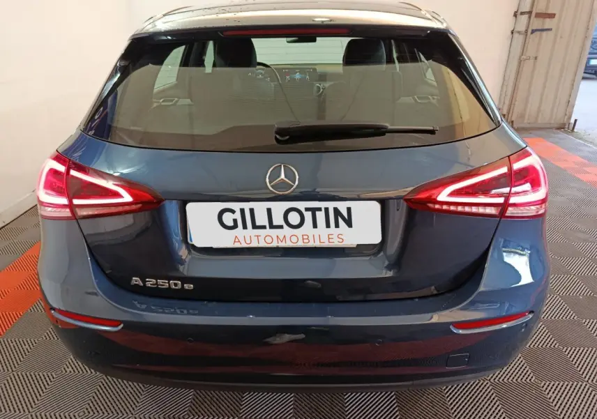 Vue arrière d'une Mercedes Classe A 250 e Business Line bleu avec feux LED allumés dans un garage.