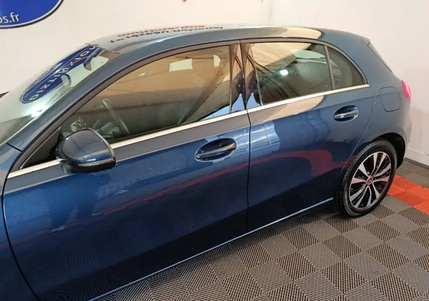 Vue latérale côté gauche d'une Mercedes Classe A 250 e Business Line bleu avec jantes alliage et rétroviseur assorti.