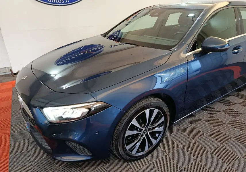 Vue 3/4 avant droit d'une Mercedes Classe A 250 e Business Line hybride rechargeable bleu métallisé avec jantes alliage bicolores.