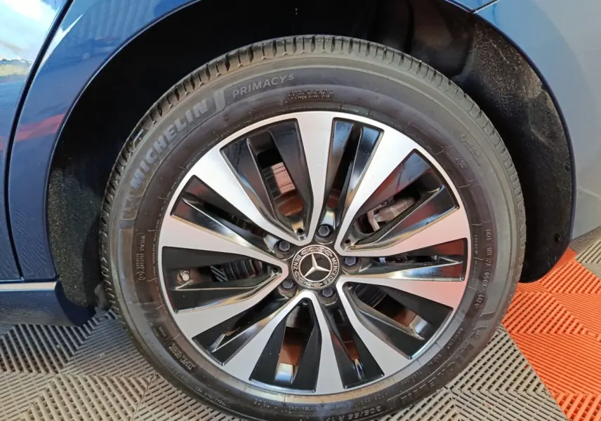 Gros plan sur la roue avant droite d'une Mercedes Classe A bleu, avec jante alliage bicolore et pneu Michelin.