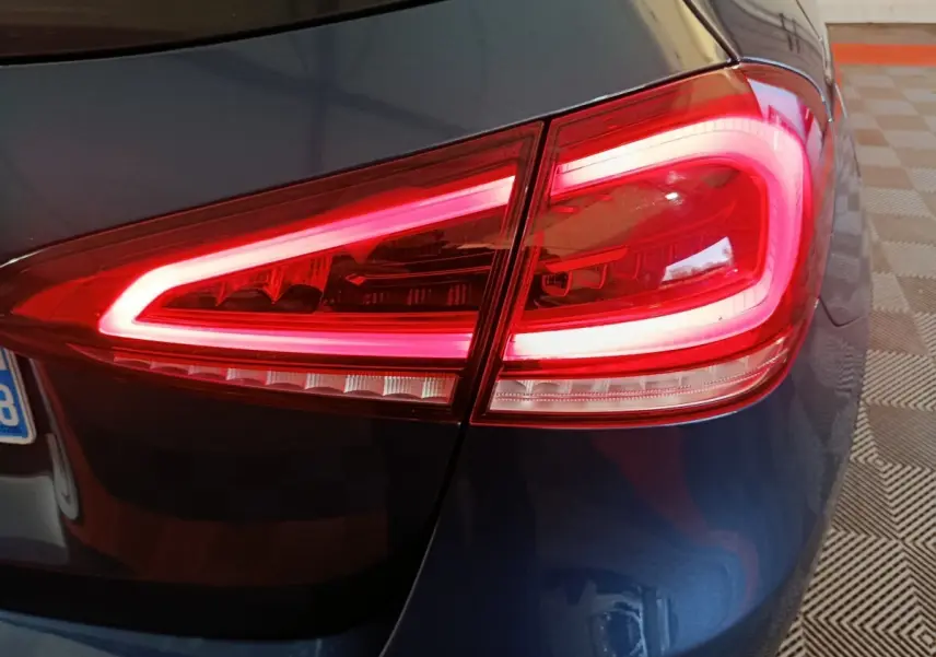 Gros plan sur le feu arrière droit rouge allumé d’une Mercedes Classe A 250 e Business Line bleu 2021.