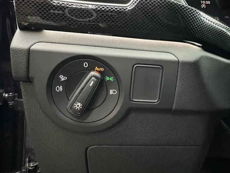 Gros plan sur le bouton de commande des phares dans l'habitacle du Volkswagen T-Cross jaune 2026, version R-Line.