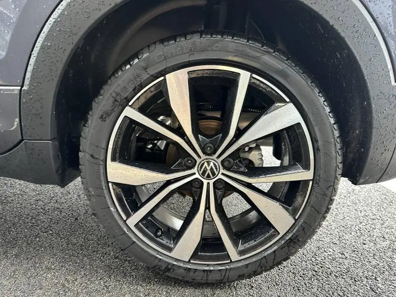 Gros plan sur la jante alliage bicolore noire et argentée du Volkswagen T-Cross 2026, avec logo VW central visible.