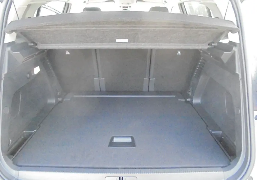 Coffre ouvert du Citroën C5 Aircross blanc banquise, vue intérieure montrant l'espace de chargement et la tablette cache-bagages.