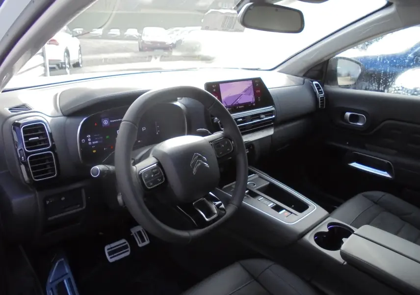 Vue intérieure côté conducteur du Citroën C5 Aircross blanc banquise, tableau de bord moderne avec écran tactile et volant multifonction.