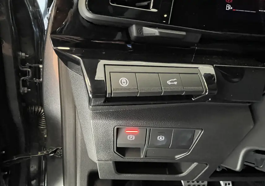 Gros plan sur les commandes de verrouillage et frein à main électrique à gauche du volant dans le Renault Rafale gris shiste.