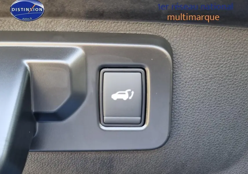 Bouton d'ouverture électrique du coffre sur panneau intérieur d'une Renault Rafale bleu sommet 2025.