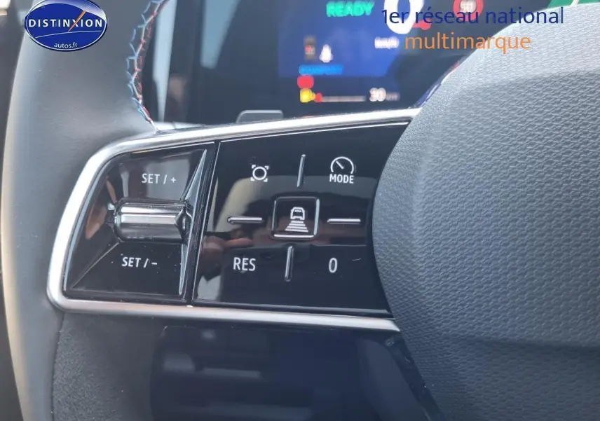 Gros plan sur les commandes multifonctions à gauche du volant du Renault Rafale bleu sommet hybride 2025.