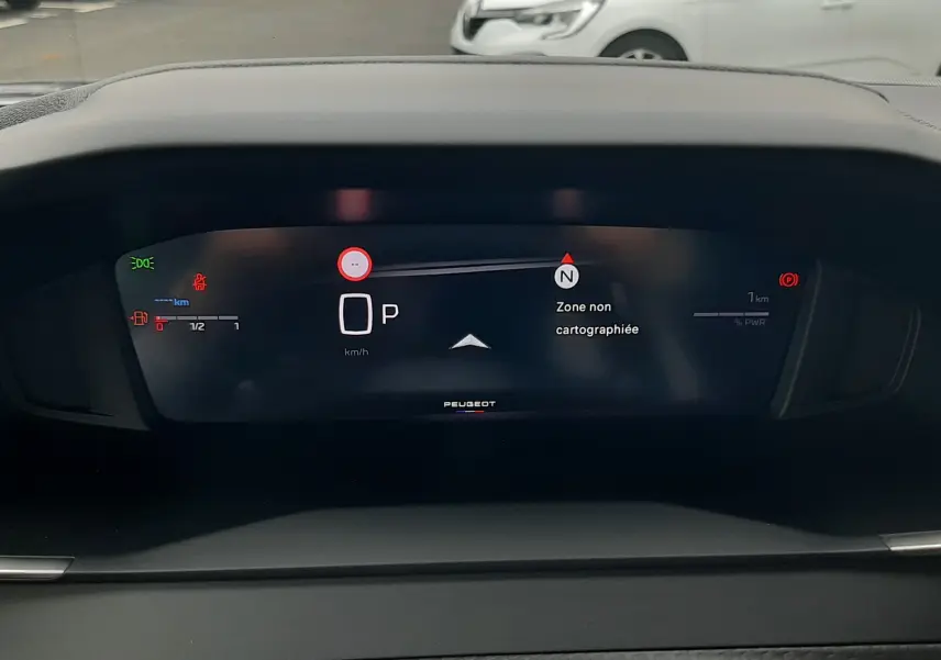 Tableau de bord numérique du Peugeot 2008 gris Artense, affichant la vitesse et la navigation en mode stationnement.
