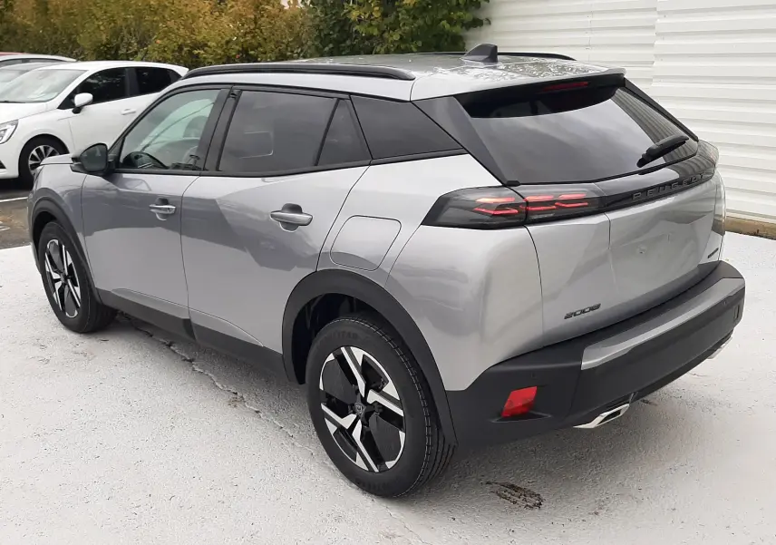 Vue 3/4 arrière droite d'un Peugeot 2008 gris Artense avec toit noir et feux arrière LED distinctifs.