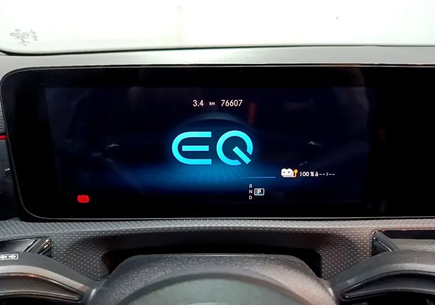 Vue rapprochée de l'écran numérique du tableau de bord de la Mercedes Classe A 250 e AMG Line, affichant le logo EQ bleu.