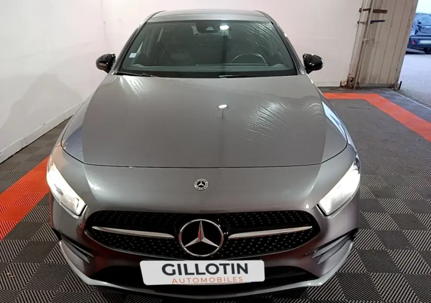 Vue avant d'une Mercedes Classe A 250 e AMG Line gris foncé avec phares LED allumés dans un garage.