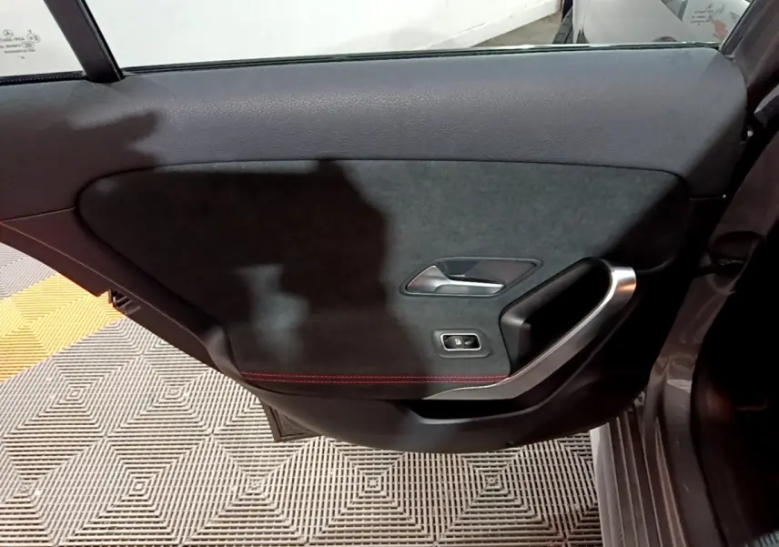 Porte arrière droite de Mercedes Classe A 250 e AMG Line 2021, garniture noire avec surpiqûres rouges et poignée alu.