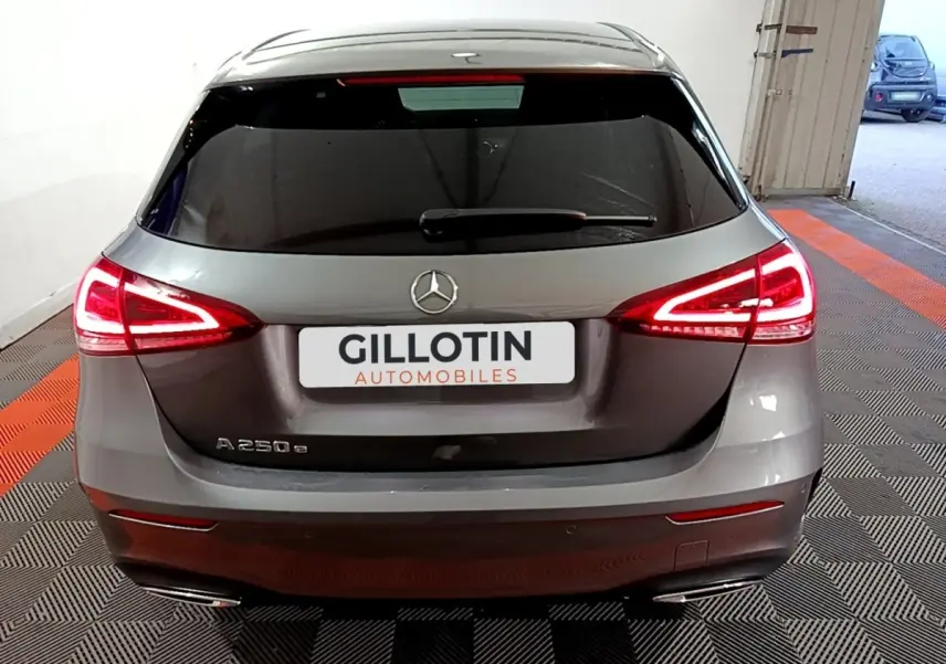 Vue arrière d'une Mercedes Classe A 250 e AMG Line gris foncé avec feux LED allumés dans un garage.