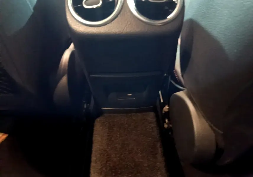 Vue rapprochée de la console arrière avec prises d’air rondes et port USB dans une Mercedes Classe A gris foncé.