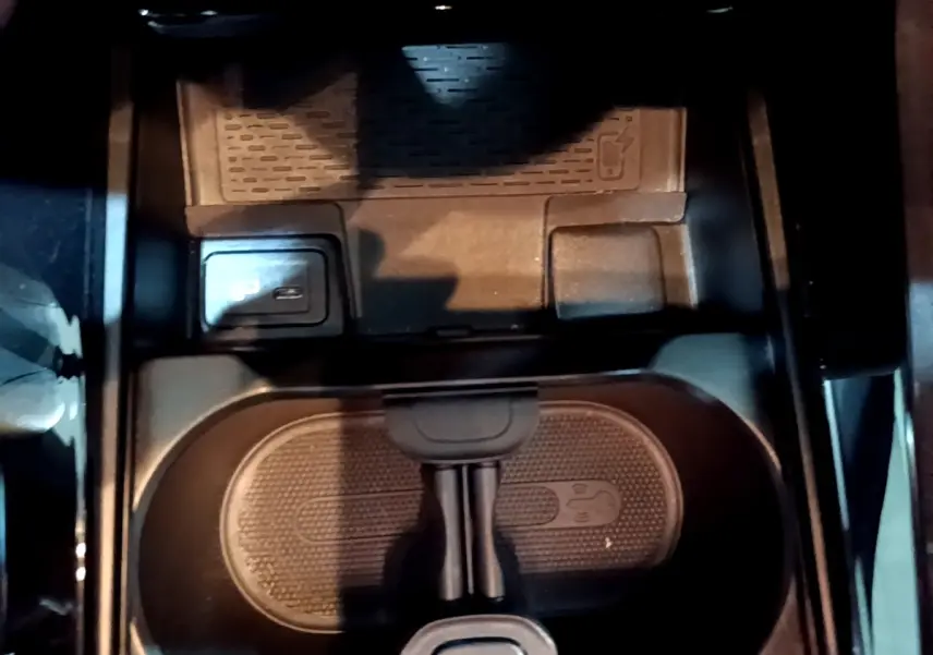 Vue rapprochée de la console centrale noire avec porte-gobelets et bouton de frein à main électrique sur Mercedes Classe A AMG Line 2021.