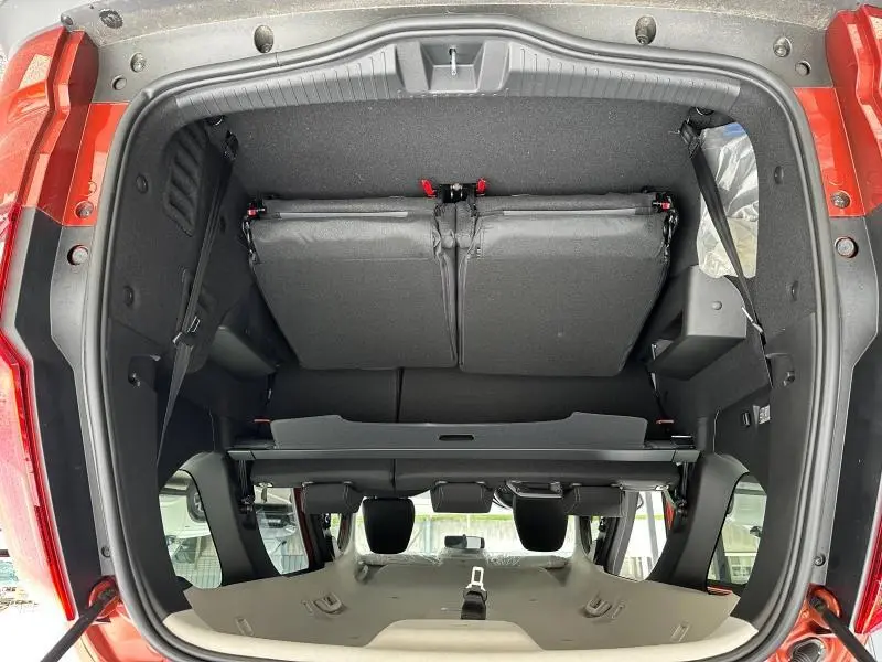Vue plongeante sur le coffre ouvert du Dacia Jogger brun Terracota, montrant la banquette arrière rabattue et l'habitacle.