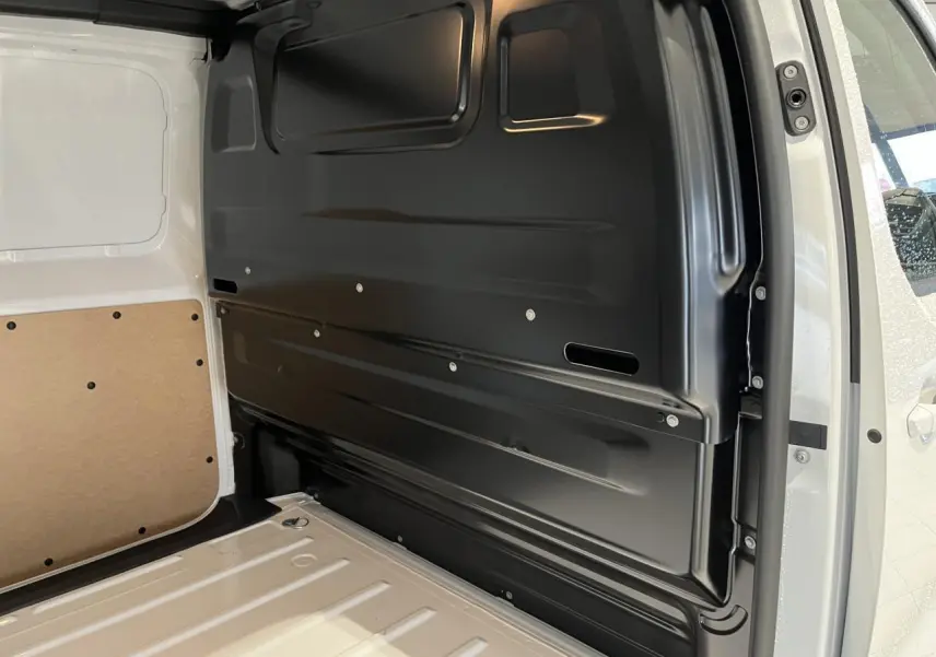 Intérieur de l'espace de chargement du Peugeot Expert Fourgon blanc 2024, vue côté droit avec cloison noire et parois blanches.