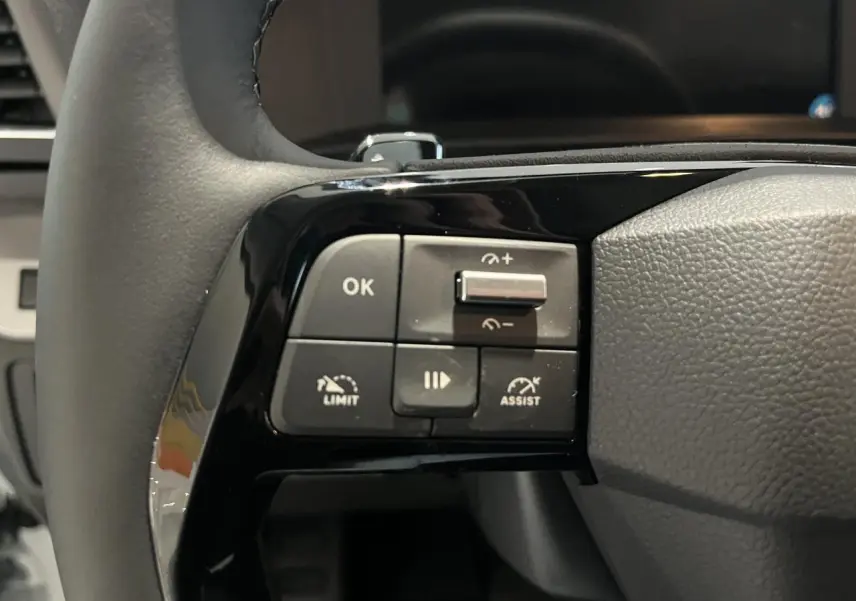 Gros plan sur les commandes de régulateur de vitesse au volant cuir noir du Peugeot Expert Fourgon blanc 2024.