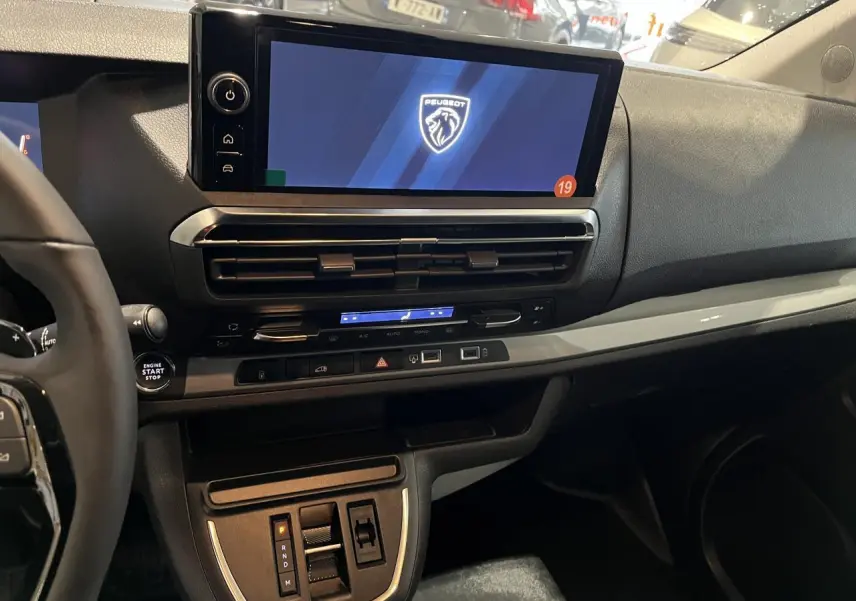 Intérieur du Peugeot Expert Fourgon 2024 vu côté passager, tableau de bord avec écran tactile et commandes modernes.