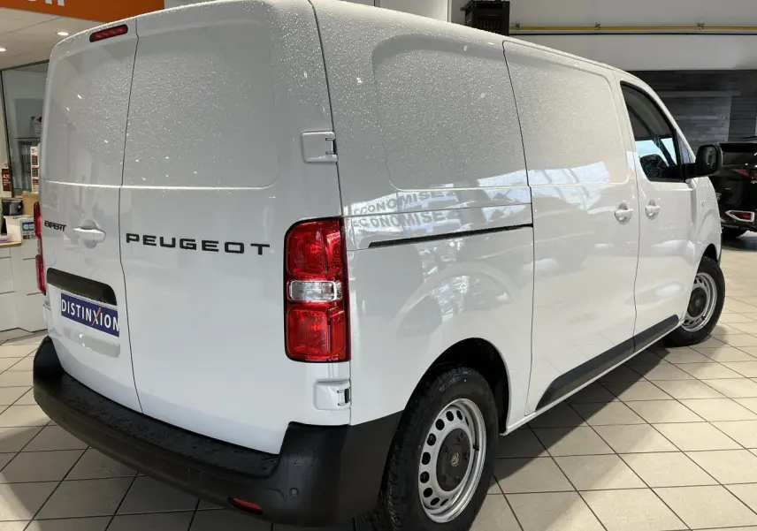 Vue 3/4 arrière droite du Peugeot Expert Fourgon blanc 2024, avec feux arrière rouges et pare-chocs noir.