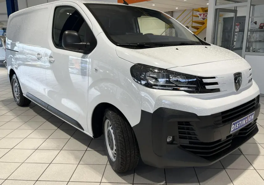 Peugeot Expert Fourgon blanc vu en 3/4 avant droit, avec calandre noire et projecteurs modernes en intérieur showroom.