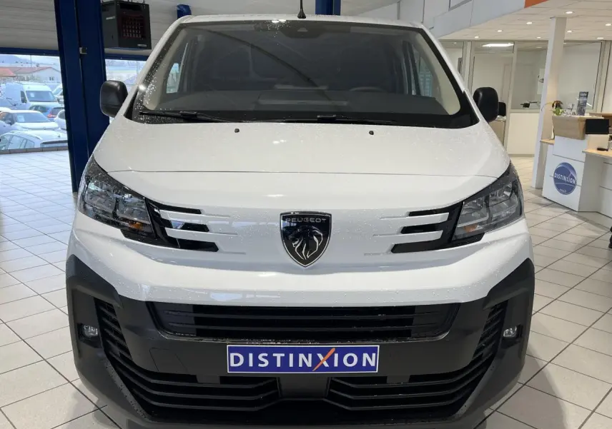 Vue frontale d'un Peugeot Expert Fourgon blanc 2024 avec logo lion et calandre noire en showroom.