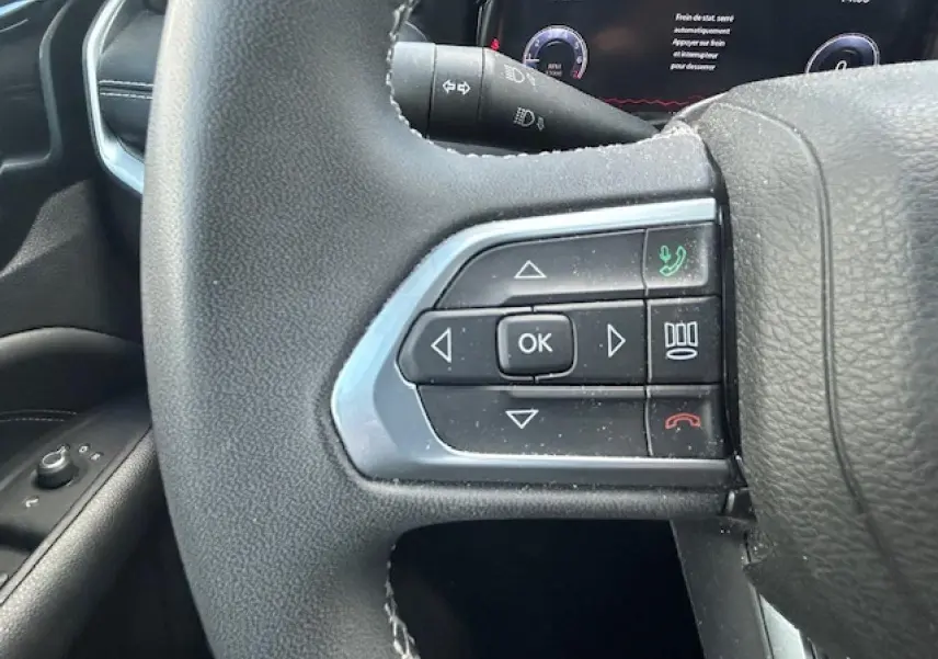 Gros plan sur les commandes multifonctions à gauche du volant du Jeep Compass 2022, intérieur noir.