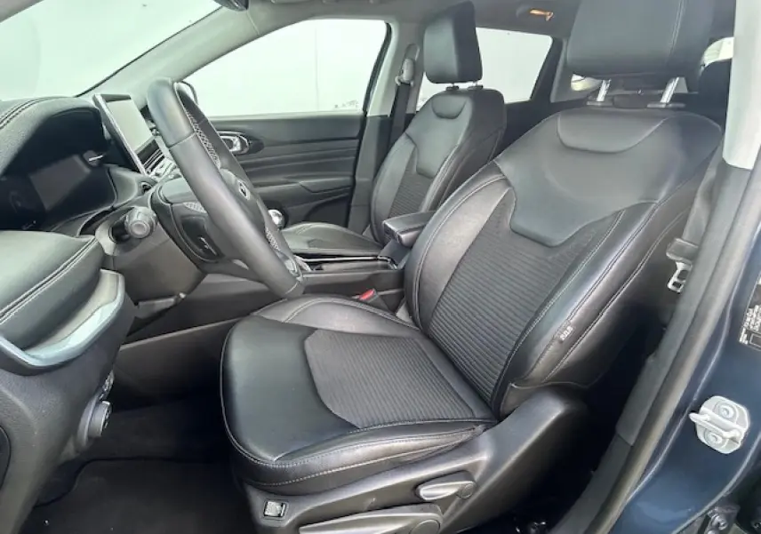 Intérieur avant droit du Jeep Compass 2022 en bleu métallisé, sièges mixte TEP/tissu noirs avec console centrale visible.