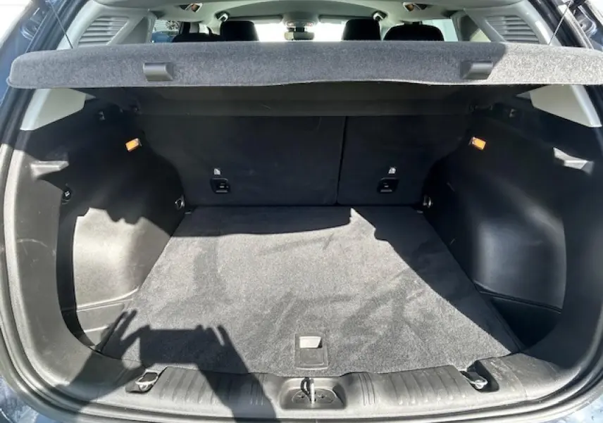 Coffre ouvert du Jeep Compass 2022 Blue Shade, montrant un espace de chargement propre et tapis noir.