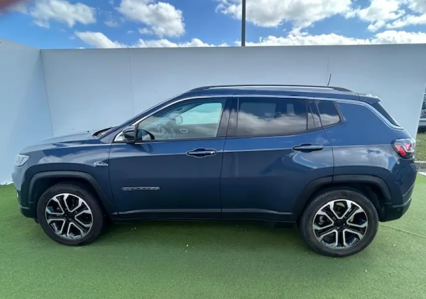 Vue latérale gauche d'un Jeep Compass 2022 bleu métallisé avec jantes alliage 18 pouces et vitres surteintées.