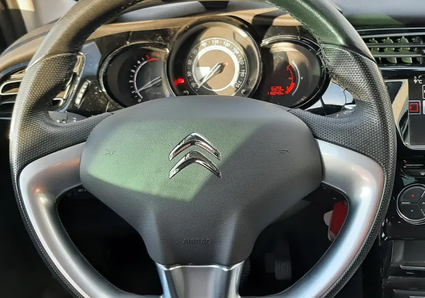 Vue rapprochée du volant en cuir noir et argenté de la Citroën C3 2016, avec tableau de bord et compteur visible.