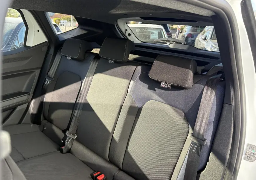 Vue intérieure arrière du Dacia Duster blanc métallisé 2024, banquette arrière en tissu Denim avec appuie-têtes et ceintures de sécurité.