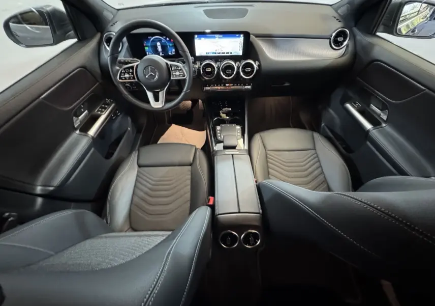 Vue intérieure avant du Mercedes GLA 250 e Business Line 2023, sièges cuir noirs et tableau de bord avec écran tactile.