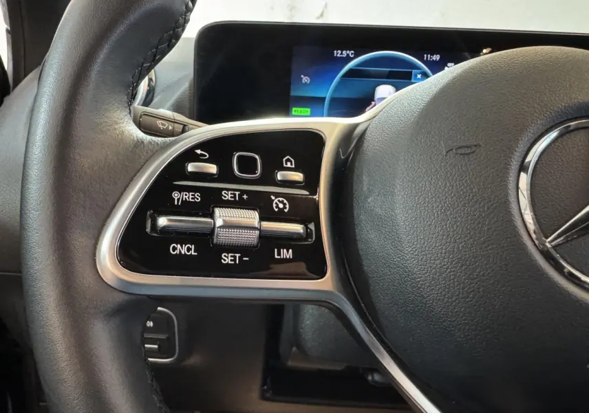 Gros plan sur le volant cuir multifonctions côté gauche du Mercedes GLA 250 e Business Line 2023 avec commandes tactiles.