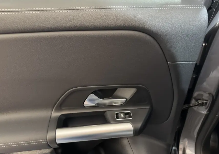 Gros plan sur la porte intérieure côté droit d’une Mercedes GLA 250 e Business Line gris foncé, avec poignée argentée.