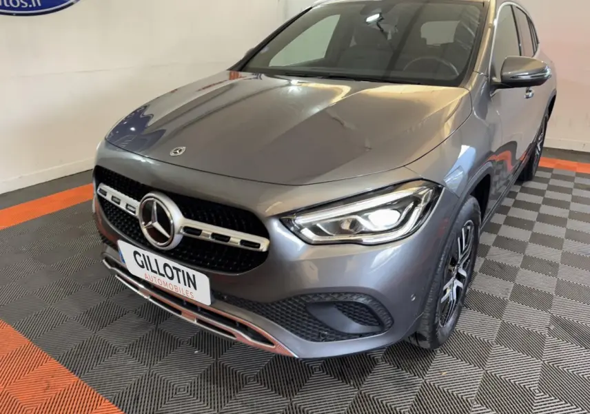 Mercedes GLA 250 e Business Line gris foncé vue 3/4 avant, avec phares LED allumés et calandre distinctive.