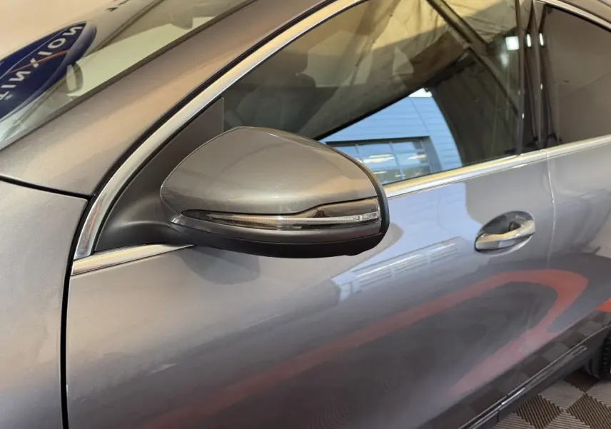Gros plan sur le rétroviseur côté gauche gris foncé d’un Mercedes GLA 250 e Business Line 2023 avec porte et poignée visibles.