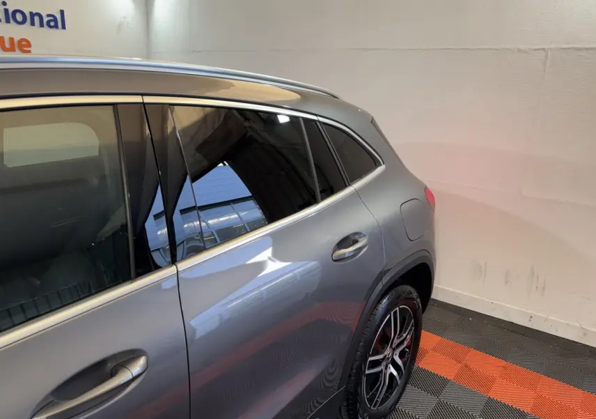Vue 3/4 arrière côté droit d’un Mercedes GLA 250 e Business Line gris foncé avec jantes alliage et vitres teintées.