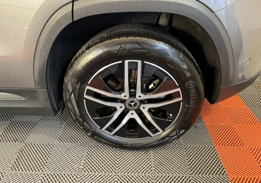 Gros plan sur la roue avant droite d’un Mercedes GLA 250 e Business Line gris foncé avec jante alliage noire et argent.