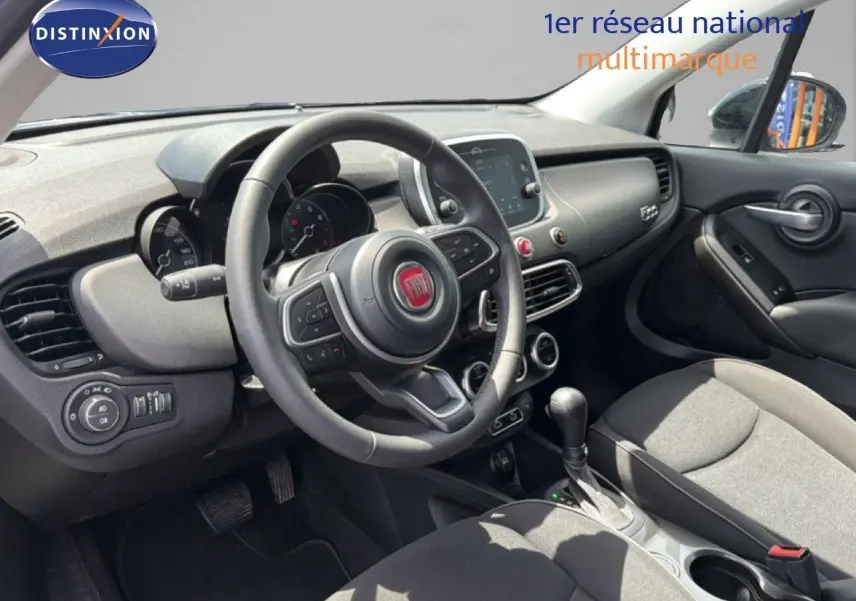 Vue intérieure côté conducteur du tableau de bord et volant de la FIAT 500X 2024, finition noire avec écran tactile central.