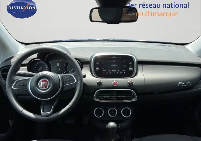 Vue intérieure du tableau de bord de la Fiat 500X 2024, avec volant multifonction et écran tactile central.