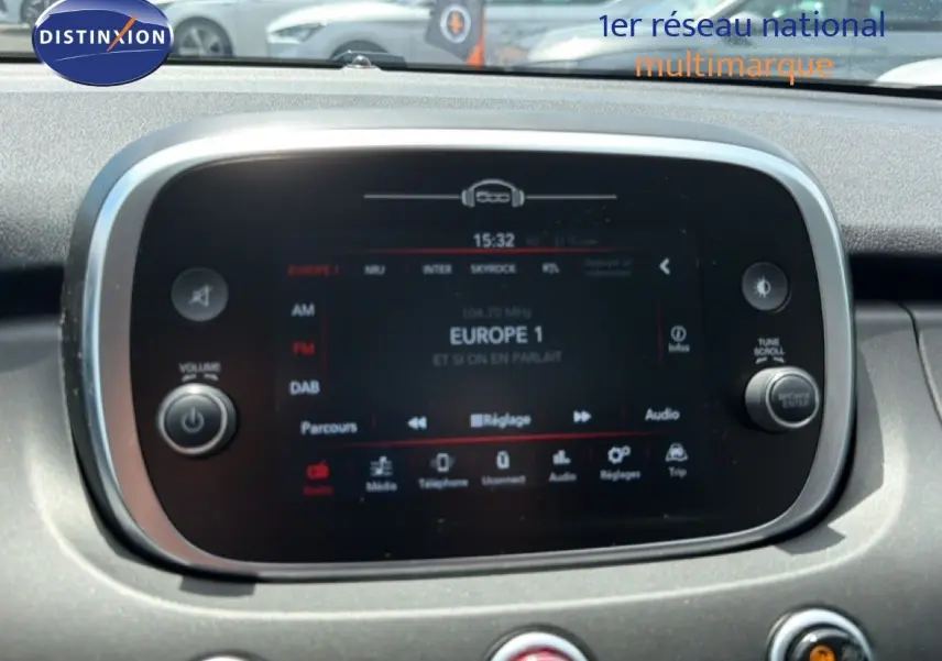 Écran tactile central de la Fiat 500X 2024, affichant la radio Europe 1, entouré de commandes circulaires.
