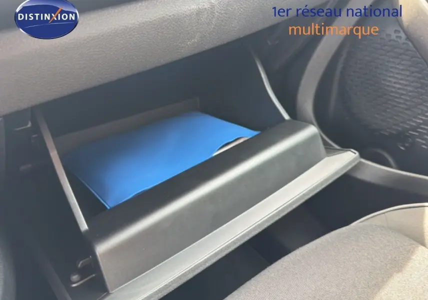 Gant de boîte à gants ouvert avec un manuel bleu à l'intérieur dans une Fiat 500X 2024, vue intérieure côté passager.