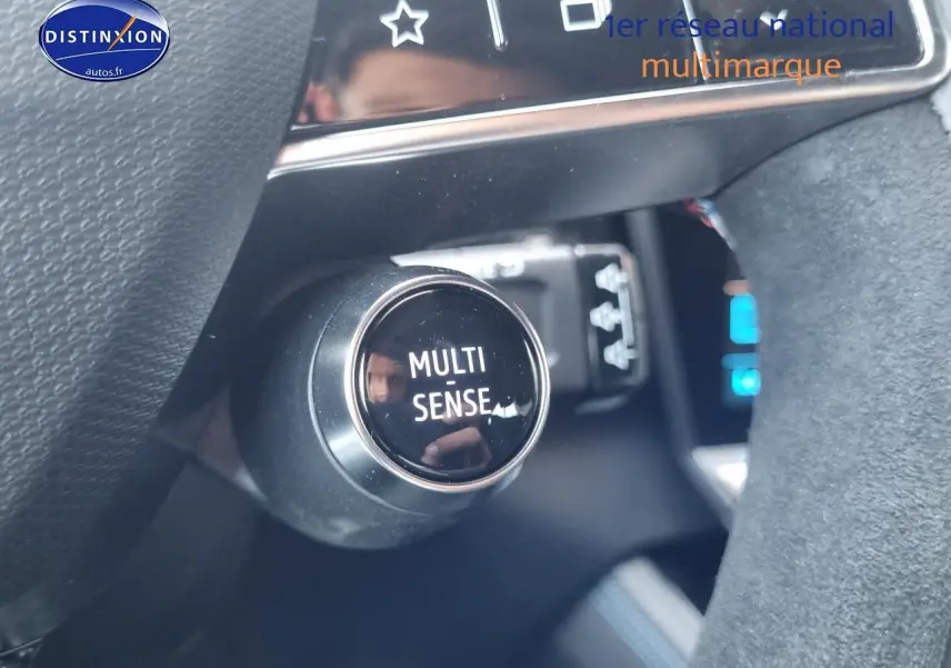 Gros plan sur le bouton Multi-Sense du tableau de bord d'une Renault Rafale noire étoile, intérieur moderne et soigné.