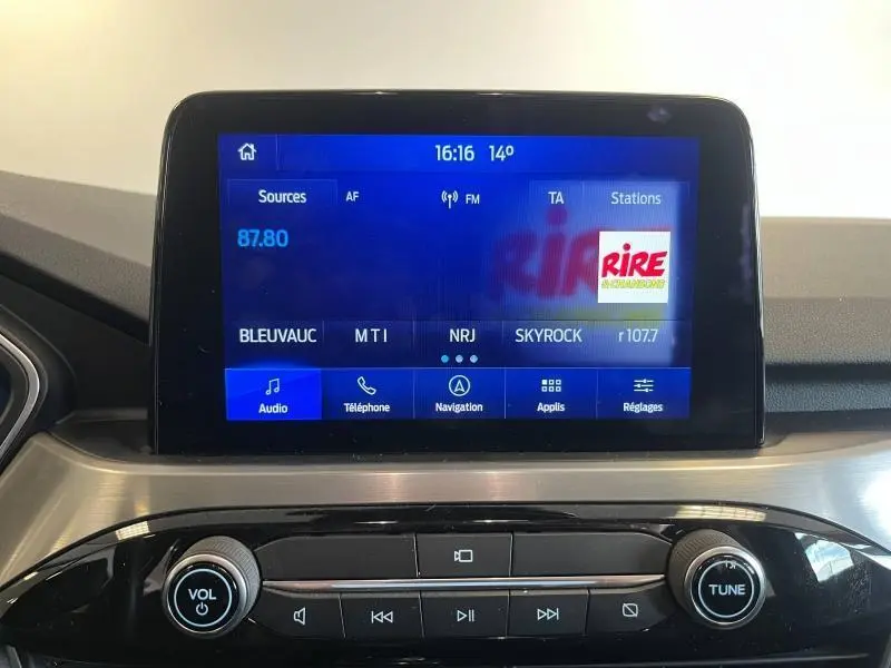 Écran tactile multimédia du Ford Kuga 2022 affichant les stations radio, avec commandes audio et navigation visibles.