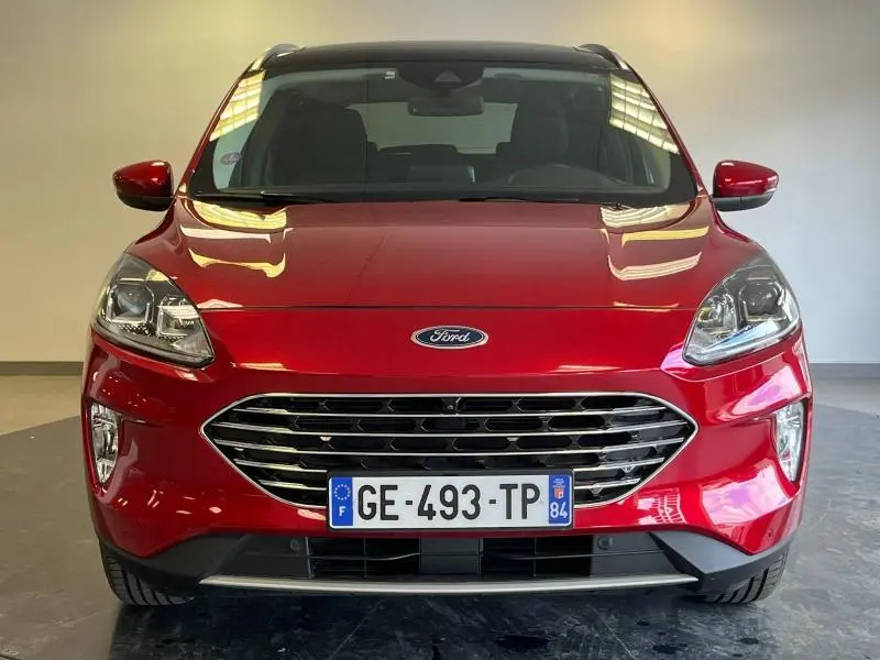Vue frontale d'un Ford Kuga 2022 rouge Premium Lucid avec calandre chromée et toit panoramique visible