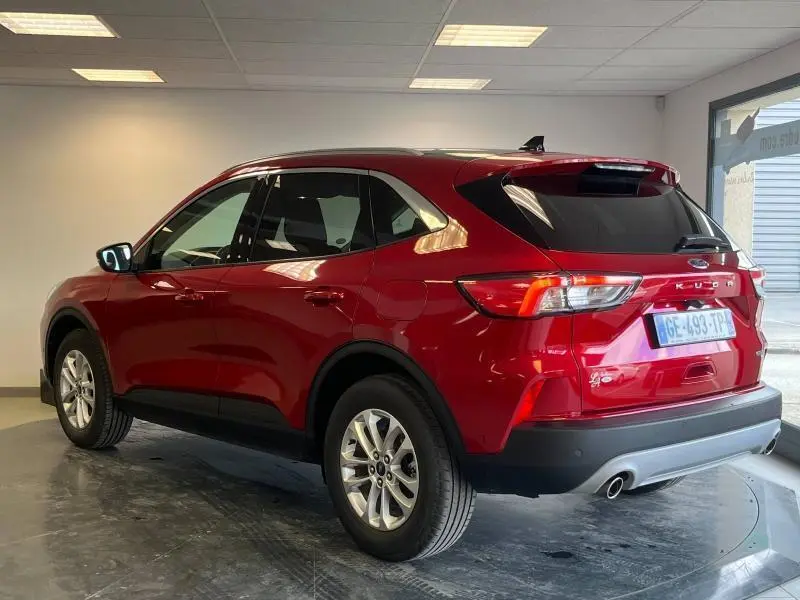 Vue 3/4 arrière droite d'un Ford Kuga 2022 rouge Premium Lucid avec toit panoramique et vitres arrière surteintées