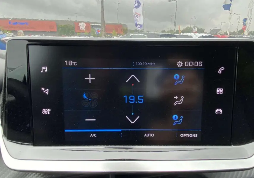 Écran tactile central de la Peugeot 208 2023 affichant la climatisation automatique à 19,5°C en intérieur.