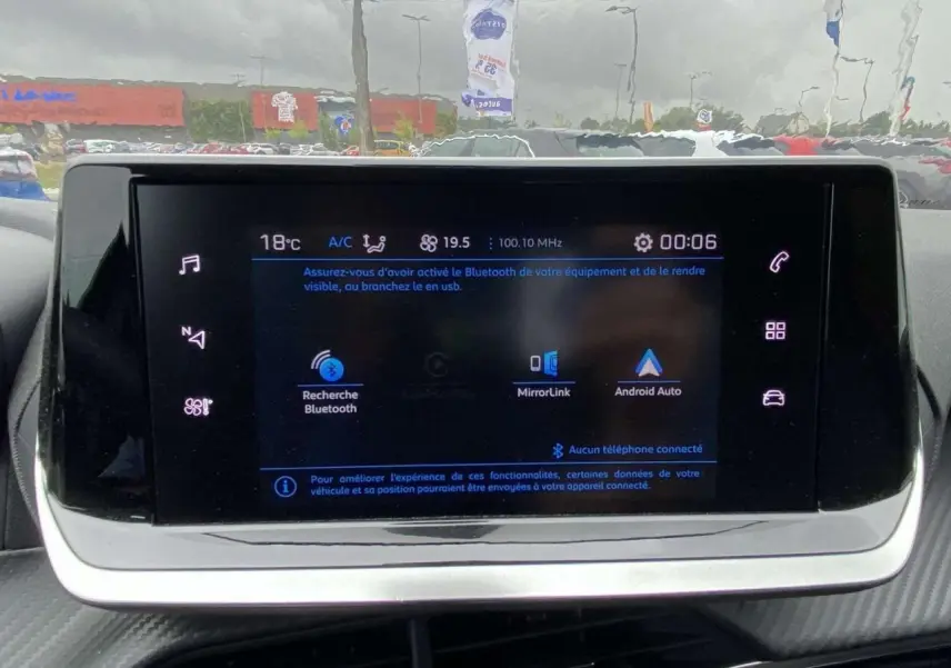 Écran tactile central de la Peugeot 208 2023 affichant les options Bluetooth, MirrorLink et Android Auto.